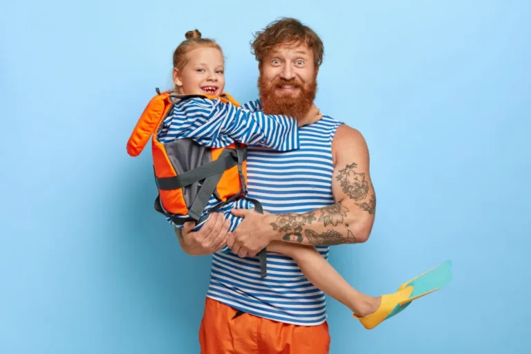 Roześmiany ojciec trzymający córkę na rękach