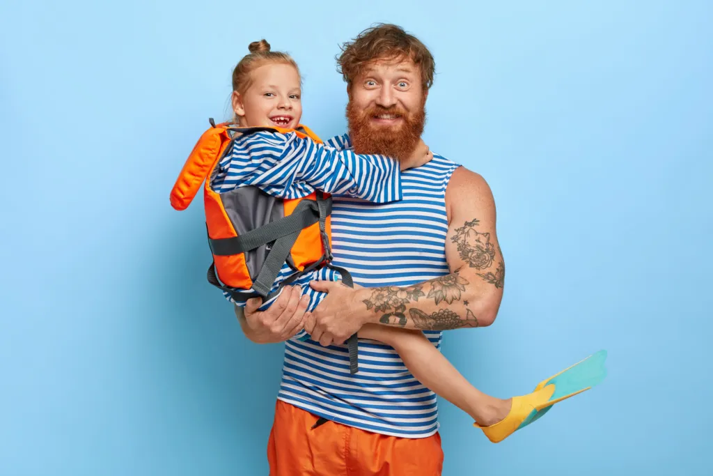 Roześmiany ojciec trzymający córkę na rękach